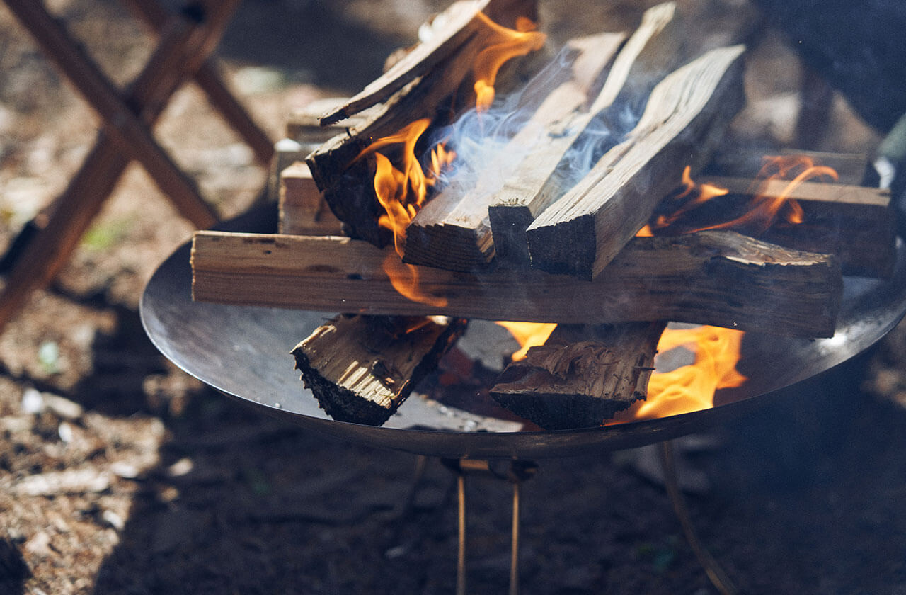キャンプの焚き火で焼く以外にも、現在は二口のバーナー（アウトドア用のガスコンロ）などを使って焼く方法もあると田中さん。焚き火で焼く場合は、しっかり火を起こし、熾火になってから焼き始めるのがいいという。